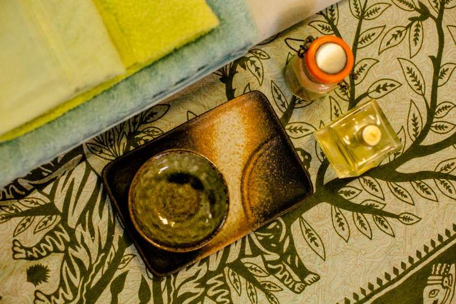 Óleo, tigela e toalhas preparados antes de uma sessão.